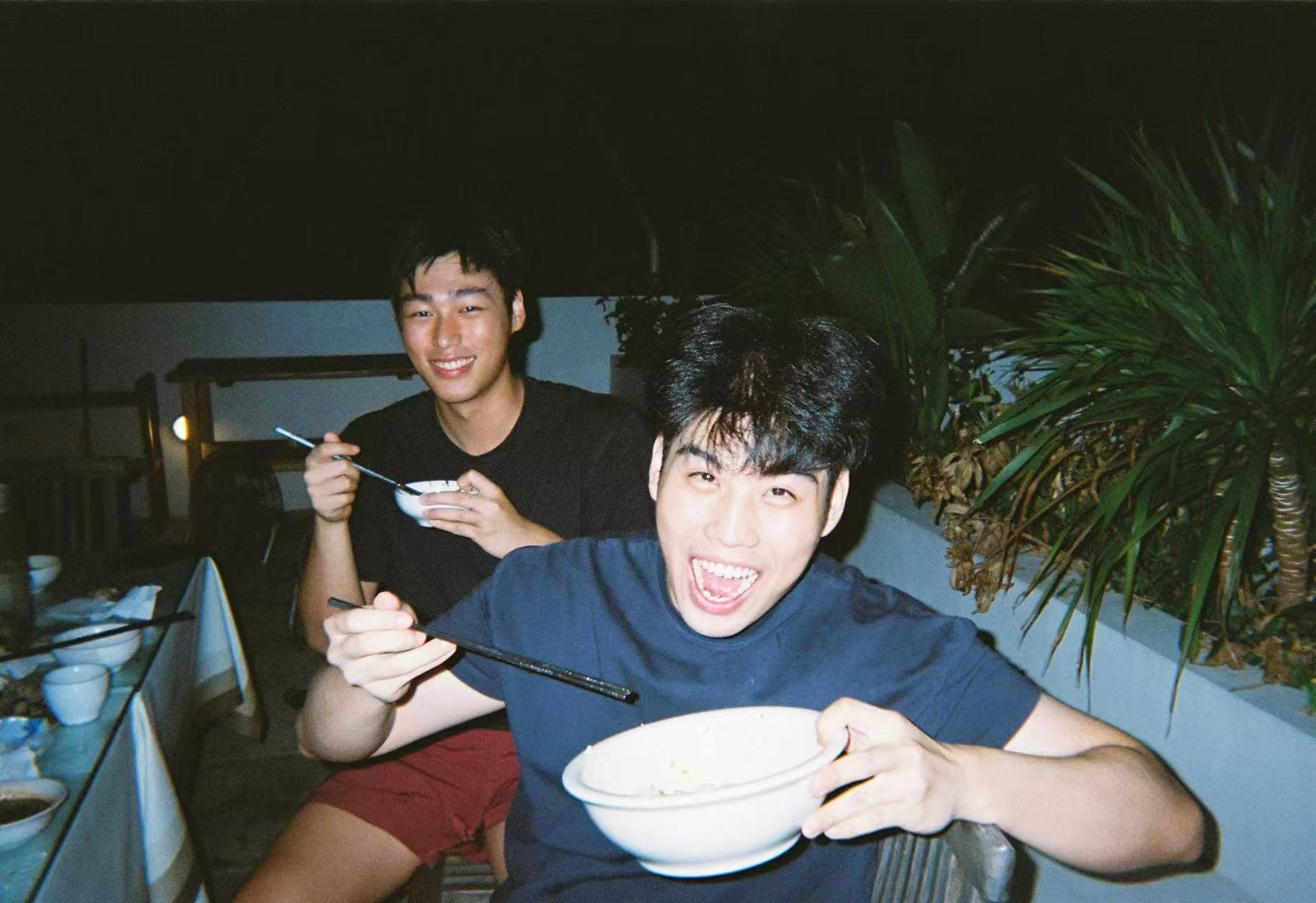 Jason Yang laughing with a friend at dinner
